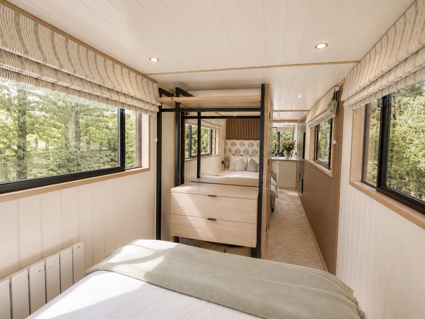 Long interior sightline inside Theta with pale panelling, oak framing and a black metal partition