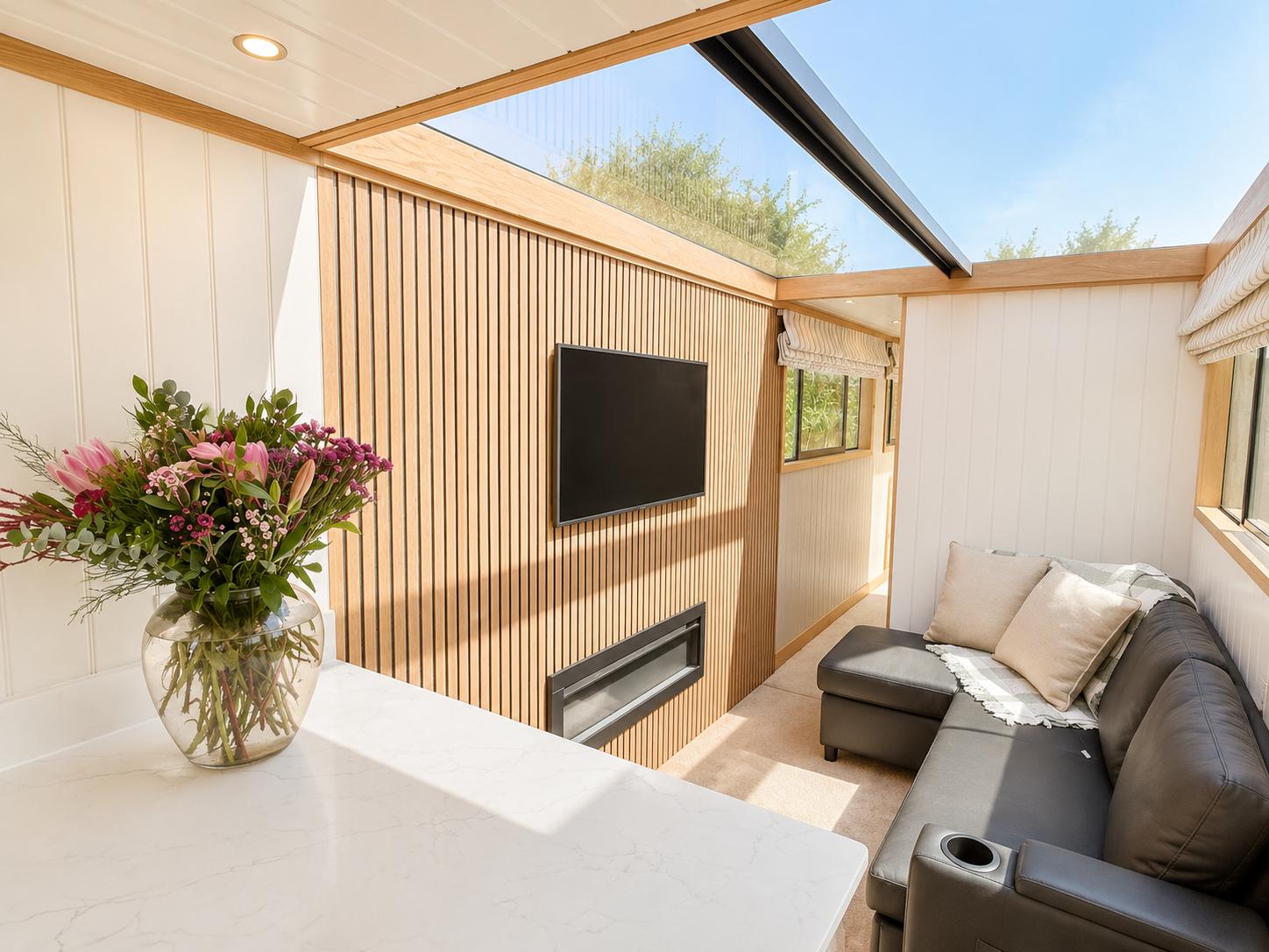 Theta saloon with a large skylight, slatted oak media wall and dark seating